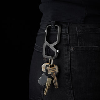 James The Mehlville Carabiner in black anodized aluminum holding keys clipped to black denim jeans