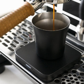 ACAIA Umbra Digital Scale in matte black weighing espresso shot with precise pouring setup