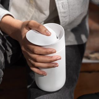 FELLOW Carter Slide Mug 12oz in white matte finish with ergonomic slide lid held by hand