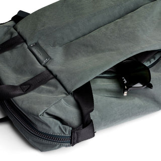 Bellroy Tokyo Totepack Compact in muted green with durable recycled fabric and hidden zipper pocket holding sunglasses