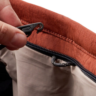 Bellroy Lite Totepack close-up of rust fabric and beige interior with hand pulling black zipper