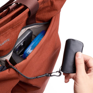 Bellroy Lite Totepack rust fabric tote bag with zippered pocket and hand holding black accessory case