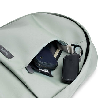 Bellroy Classic Backpack Compact in muted green showing front pocket with keys and wallet inside