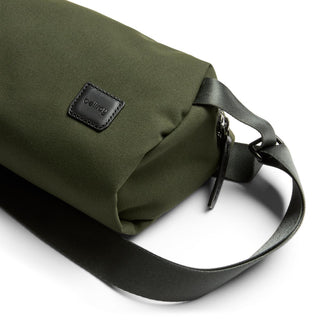 Bellroy Classic Sling 3L in olive green fabric with black leather logo and adjustable strap close-up