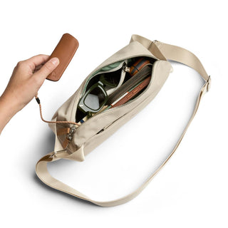 Bellroy Classic Sling 3L in beige with leather pull tab and organized interior accessories