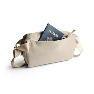 Bellroy Classic Sling 3L in light beige fabric with passport partially visible in main zippered compartment