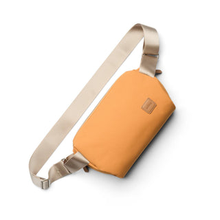 Bellroy Classic Sling 5L in ochre with smooth recycled fabric and adjustable beige strap shown flat