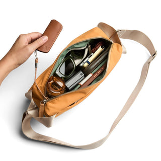 Bellroy Classic Sling 5L in tan with beige strap showing organized interior and leather key pouch