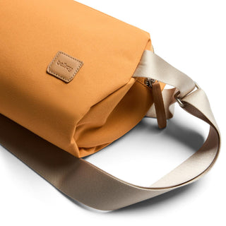 Bellroy Classic Sling 5L in ochre with beige strap and recycled fabric texture close-up view