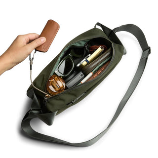 Bellroy Classic Sling 5L in green with organized interior and wrist key pouch held in hand
