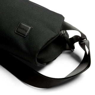 Bellroy Classic Sling 7L in black recycled fabric with leather logo patch and adjustable strap close-up