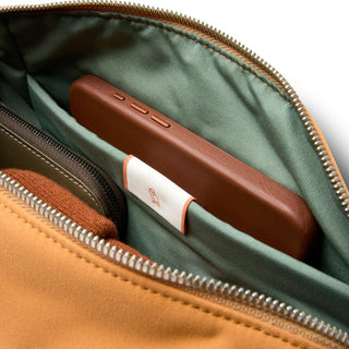 Bellroy Classic Sling 7L interior showing organized pockets with soft green lining and tan fabric exterior