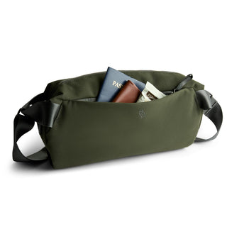 Bellroy Classic Sling 7L in olive green fabric showing front zip pocket with travel essentials inside