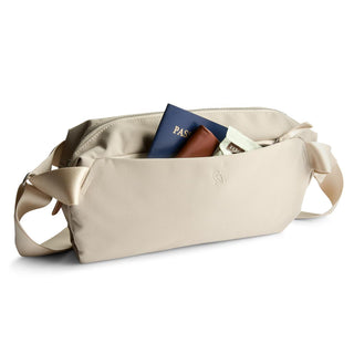 Bellroy Classic Sling 7L in beige with smooth fabric and front pocket holding travel essentials