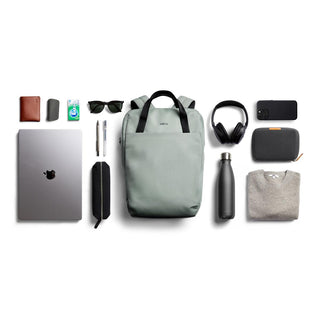 Bellroy Via Workpack in light grey with black straps displayed alongside tech and travel essentials