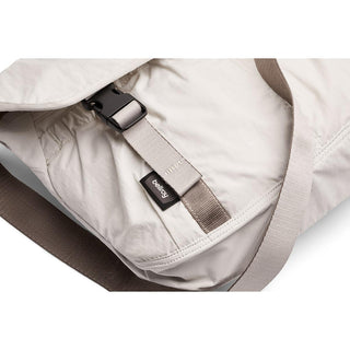 Bellroy Cinch Messenger Bag close-up showing light fabric and secure buckle detail with logo tag