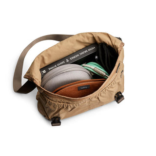 Bellroy Cinch Messenger Bag open showing organized interior with zipper pouch and personal items inside