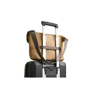 Bellroy Cinch Messenger Bag in tan recycled nylon with adjustable shoulder strap on luggage handle