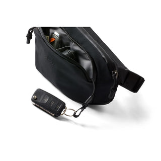Bellroy Venture Hip Pack 1.5L in black with zipper open showing organized interior compartments