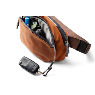 Bellroy Venture Hip Pack 1.5L in tan brown fabric with multiple compartments and car key attached