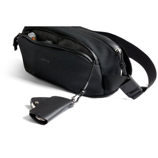Black Bellroy Venture Ready Sling 2.5L with zip pocket open and attached key holder in recycled nylon blend