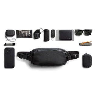 Bellroy Venture Ready Sling 2.5L in black nylon surrounded by everyday carry essentials laid out flat