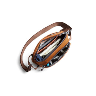 Bellroy Venture Ready Sling 2.5L open showing organized compartments and brown adjustable strap