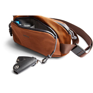 Bellroy Venture Ready Sling 2.5L in brown fabric with adjustable strap and key accessory attached