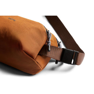 Bellroy Venture Ready Sling 2.5L in warm brown with durable strap and dual zipper pulls close-up view