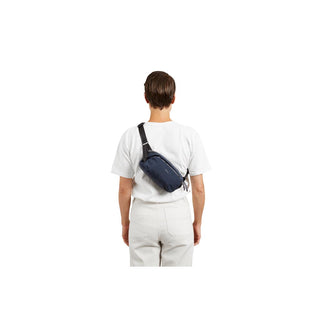 Bellroy Venture Ready Sling 2.5L in navy blue worn crossbody with adjustable strap on model back