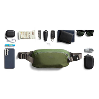 Bellroy Venture Ready Sling 2.5L in green recycled nylon displayed with everyday carry items arranged around it