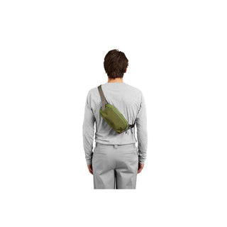 Bellroy Venture Ready Sling 2.5L worn crossbody in olive green recycled fabric on model back