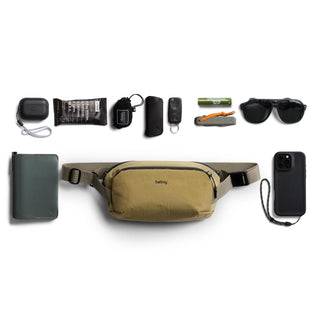 Bellroy Venture Ready Sling 2.5L in tan with multiple everyday essentials neatly arranged around it