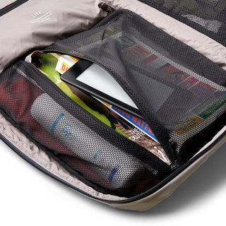 Bellroy Lite Travel Pack 30L showing organized mesh compartments with books and a tablet inside