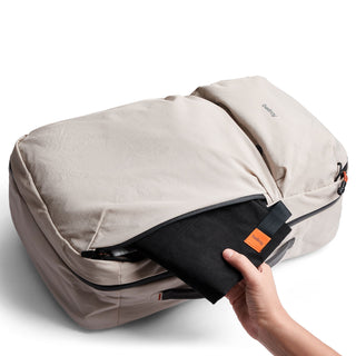 Bellroy Lite Travel Pack 30L in beige recycled fabric with black removable pouch held by hand