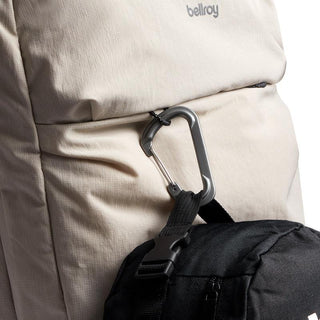 Bellroy Lite Travel Pack 30L in beige fabric with a metal carabiner and black strap detail close-up