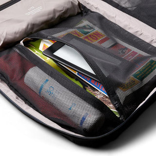 Bellroy Lite Travel Pack 30L interior with mesh pockets holding snacks tablet silver bottle on tan lining