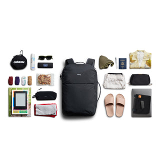 Bellroy Lite Travel Pack 30L black backpack with travel essentials neatly arranged around it