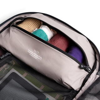 Bellroy Lite Travel Pack 30L showing organized interior with rolled clothes in light beige fabric compartment