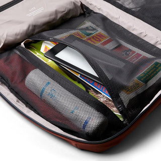 Bellroy Lite Travel Pack 30L interior with mesh pockets holding a water bottle, tablet, and travel items