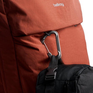 Bellroy Lite Travel Pack 30L in rust fabric with black accessory attached by carabiner clip on side pocket