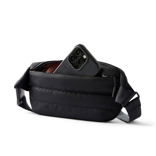 Bellroy Laneway Belt Bag in black with front zipper pocket holding a smartphone, lightweight design