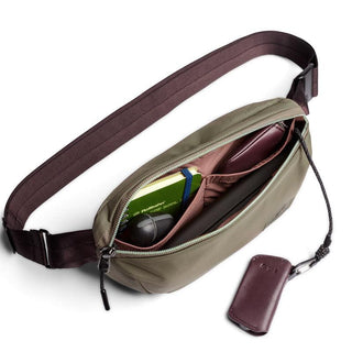 Bellroy Laneway Belt Bag in olive green with dark strap showing organized interior compartments