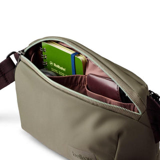 Bellroy Laneway Belt Bag in olive green showing organized interior with notebook and wallet compartments