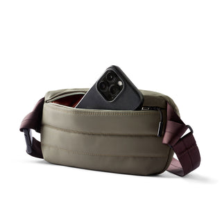 Bellroy Laneway Belt Bag in olive green with front zip pocket holding a smartphone