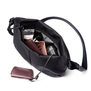 Bellroy Laneway Sacoche black recycled fabric crossbody bag with open zipper showing interior items