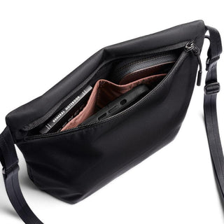 Bellroy Laneway Sacoche in black showing open zippered compartments with phone and notebook inside