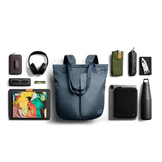 Bellroy Laneway Totepack in slate blue fabric surrounded by everyday travel essentials arranged flat
