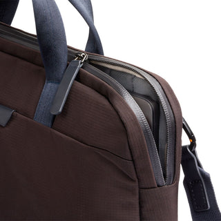 Bellroy Tokyo Laptop Bag 14” in dark fabric with blue handles and partially open zipper showing laptop inside