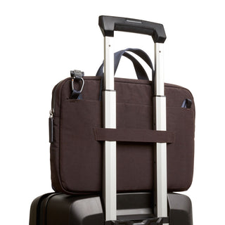 Bellroy Tokyo Laptop Bag 14" in dark brown fabric secured on a suitcase handle strap